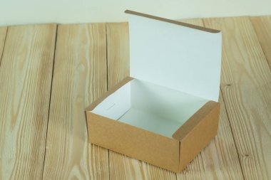 Kopya alanı ile parlak ahşap masa üzerinde sahte için kahverengi karton kutu boş açıldı.
