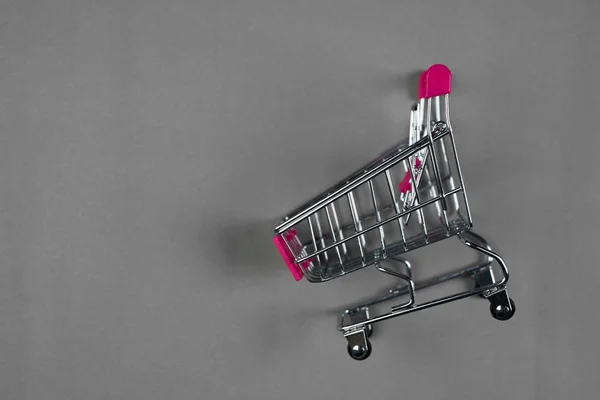 灰色の背景にカートやスーパー マーケットのトロリーのショッピング ビジネス金融ショッピングのコンセプト アイデア — ストック写真