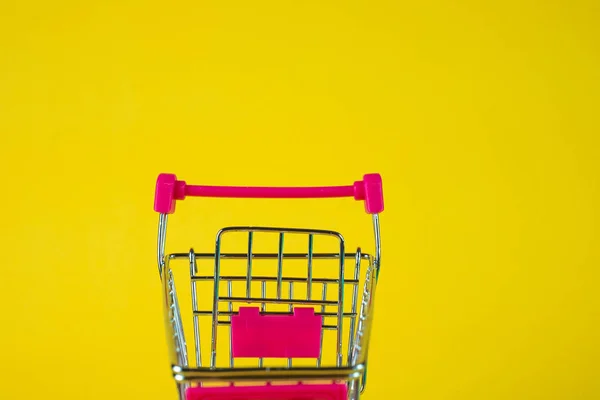 Nákupní košík nebo supermarket vozíku na žlutém podkladu, Bušín — Stock fotografie