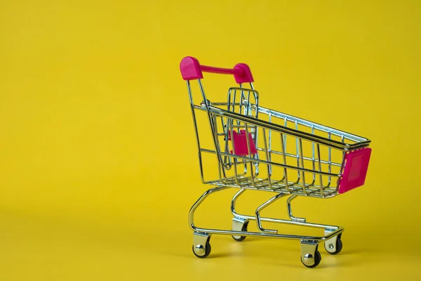 Shopping cart eller stormarknad vagn på gul bakgrund, busin — Stockfoto