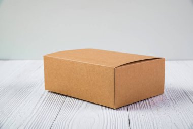 Boş paket kahverengi karton kutu veya parlak ahşap masa üstünde tepsi