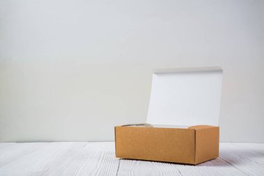 Boş paket kahverengi karton kutu veya parlak ahşap masa üstünde tepsi