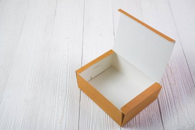 Boş paket kahverengi karton kutu veya parlak ahşap masa üstünde tepsi
