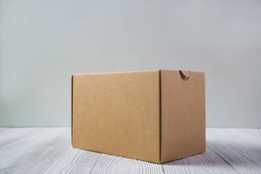 Boş paket kahverengi karton kutu veya parlak ahşap masa üstünde tepsi
