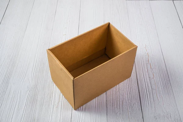 Пустой пакет коричневый картонный ящик или лоток на светлом деревянном столе — стоковое фото