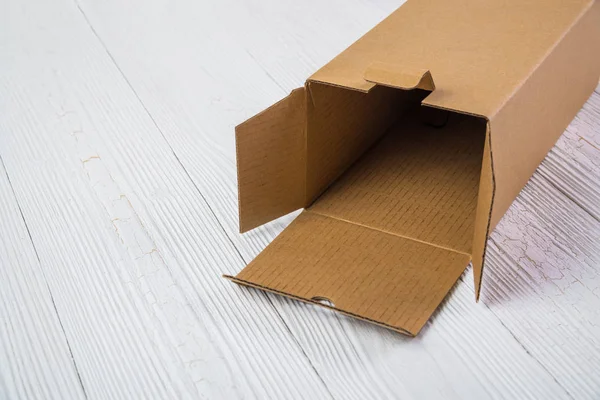 Pacote vazio caixa de papelão marrom ou bandeja em mesa de madeira brilhante — Fotografia de Stock