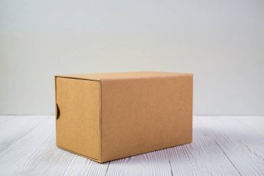 Boş paket kahverengi karton kutu veya parlak ahşap masa üstünde tepsi