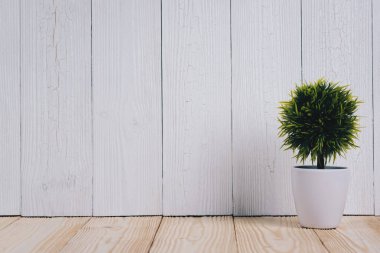 Küçük dekoratif ağacı ahşap masa üzerinde beyaz cam aranjman. arka plan