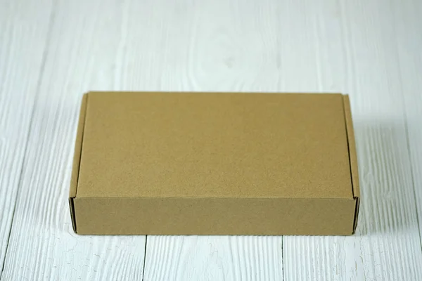 Empty Package brown cardboard box or tray on bright wooden table