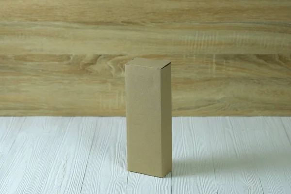 Άδειο κουτί από χαρτόνι πακέτο καφέ ή θήκη στο φωτεινό ξύλινο τραπέζι — Φωτογραφία Αρχείου