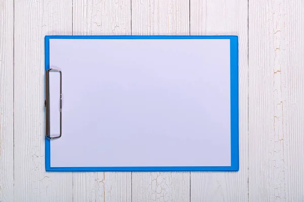 Portapapeles con hoja de papel blanco en blanco sobre tabla de madera vista superior wi — Foto de Stock
