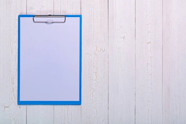 Portapapeles con hoja de papel blanco en blanco sobre tabla de madera vista superior wi — Foto de Stock