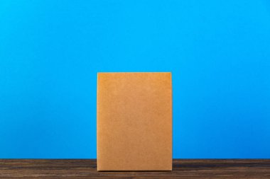 Koyu ahşap tabl üzerinde sahte için kahverengi karton kutu boş kapandı