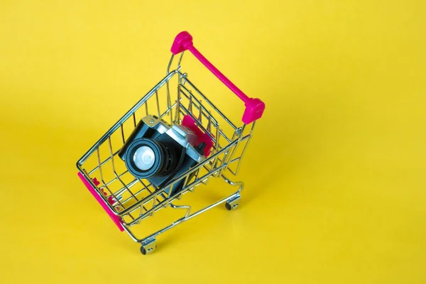 Mini kamera leksak och shopping cart eller stormarknad vagn på yell — Stockfoto