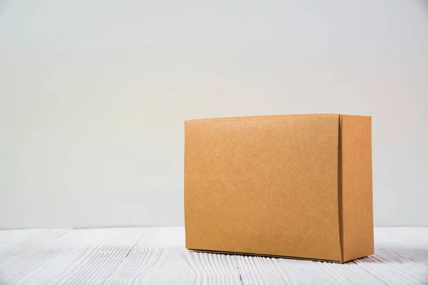Paquete vacío caja de cartón marrón o bandeja en mesa de madera brillante — Foto de Stock