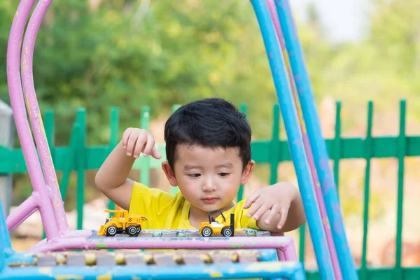 Pequeño niño asiático jugando diapositiva en el patio de recreo bajo el sunli — Foto de Stock