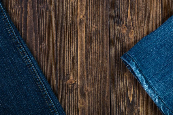 Colección de vaqueros deshilachados o vaqueros azules en madera oscura rugosa — Foto de Stock