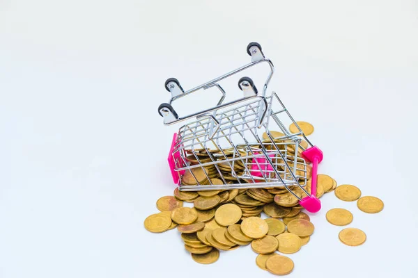 Pila de monedas y carrito de la compra o carrito de supermercado en blanco — Foto de Stock