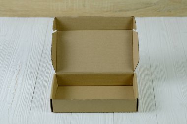 Boş paket kahverengi karton kutu veya parlak ahşap masa üstünde tepsi