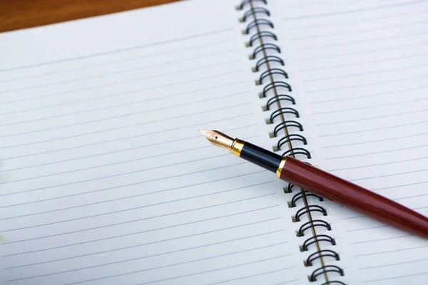 Close up of fountain pen or ink pen with notebook paper on woode — Stock Photo, Image