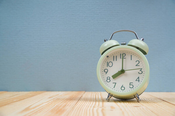 Retro vintage alarm clock on wood table, time concept.