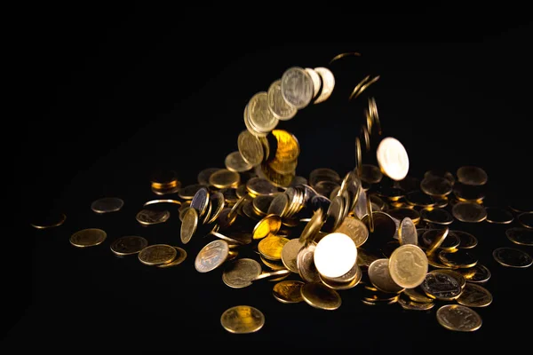 Falling gold coins money in dark background, business concept.