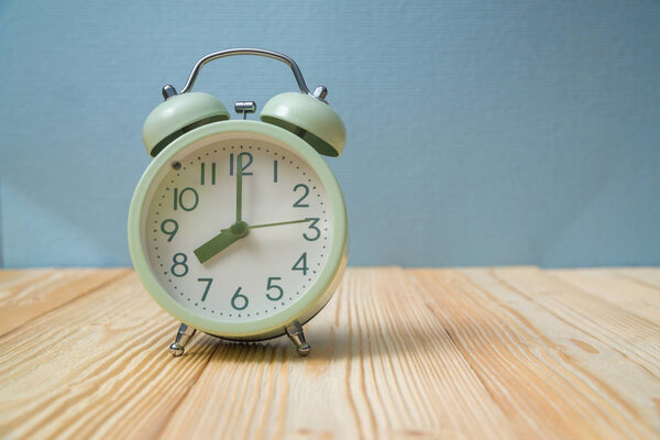 Retro vintage alarm clock on wood table, time concept idea.