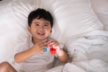 3 yıl eski sevimli Asya ufaklık evde yatakta, çocuk yalan 