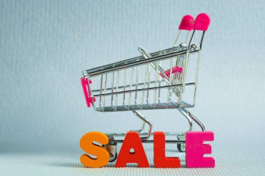 Satılık renkli ahşap metin ve alışveriş sepeti ya da süpermarket troll