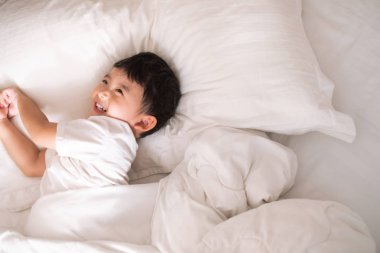 3 yıl eski sevimli Asya ufaklık evde yatakta, çocuk yalan 