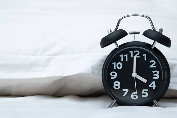 Reloj despertador vintage en la cama en el dormitorio en casa, despierta o sé —  Fotos de Stock