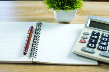 Dolma kalem veya tükenmez kalem defter kağıt ve ahşap çalışma masa kopya alanı, office Danışma konsept fikir ile hesap makinesi ile. Üstten Görünüm.