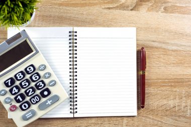 Dolma kalem veya tükenmez kalem defter kağıt ve ahşap çalışma masa kopya alanı, office Danışma konsept fikir ile hesap makinesi ile. Üstten Görünüm.