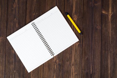 Defter ve kalem ahşap masa üstüne boş beyaz kağıt w görüntülemek