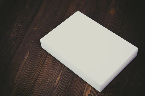 Lege witte geschenkdoos of lade voor mock up op donker houten tafel wi — Stockfoto