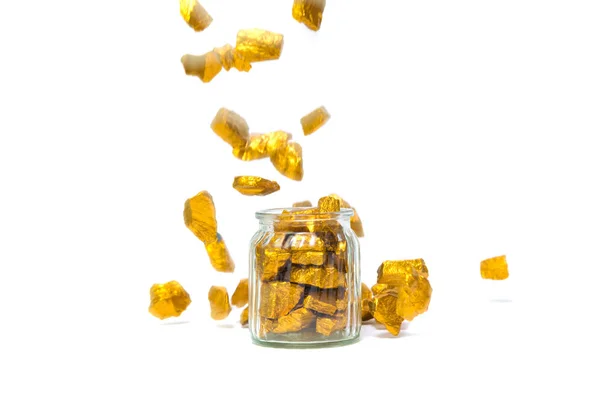 Falling gold nuggets or gold ore and glass jar isolated on white