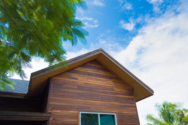 Telhado da casa com árvore verde, céu azul e nuvem . — Fotografia de Stock