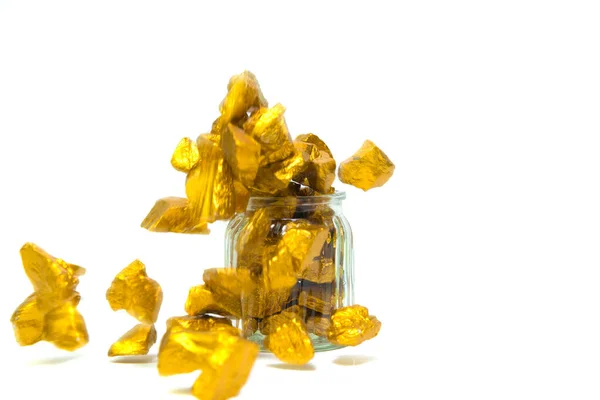 Falling gold nuggets, gold ore , precious stone or lump of golden stone and glass jar isolated on white background.