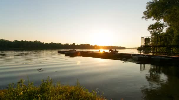 日落时船停泊的时间 日落在河上 码头为小船 人们登上码头和运输在日落 小船停泊在日落在河 — 图库视频影像