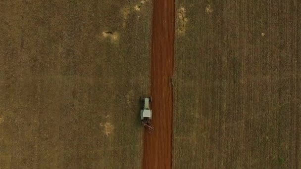 トラクター トラクター耕起フィールド トラクター フィールドを耕してトラクターで飛びとフィールドの上の飛行のトラクターの 撮フィールド航空写真ビュー — ストック動画