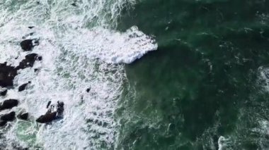 okyanus dalgası ve kayaların üst görünümü, Pasifik Okyanusu'nun kayalık kıyılarının havadan görünümü, Rocky Shore'a Doğru Koşan Dalgaların Havadan Vurulması, kayalara çarpan dalgaların havadan görünümü