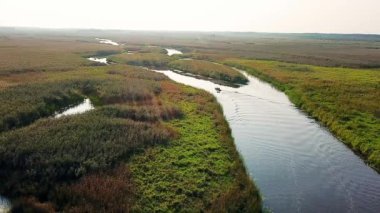 küçük bir nehir üzerinde bir motorbot insanların havadan görünümü, Pripyat Delta su yolları aşağı yol yapım bir turist teknehavadan görünümü, nehirde motorbot üzerinde uçmak