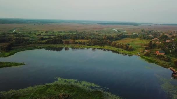 vue aérienne du village au bord du lac dans la brume du matin, vue aérienne du lac au lever du soleil, brouillard et soleil sur les rivières, vue aérienne du brouillard sur le marais à l'aube 