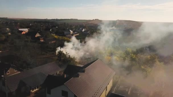 村の秋の火災からの煙の空中ビュー 乾燥草とリードバーン 火災から煙は秋に郊外の民間部門の上のスペースを満たしています — ストック動画