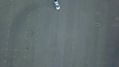 Oto-odromdaki polis arabasının hava görüntüsü, asfalt otodrom yol işaretleri ehliyet sınavı, yarış pistinde araba yarışı.