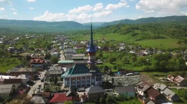 Merry Mezarlığı 'ndaki kilisenin hava manzarası, Romanya' nın Maramures kentindeki Ruhani ve Neşeli Mezar Taşlarıyla Renkli Mezarlar, Mutlu Mezarlıkta süslenmiş mezar taşları.