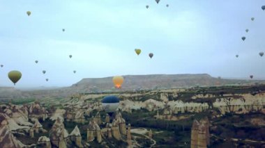 Kapadokya 'da güneş doğarken Balon' un havadan görünüşü, Cappadocia kayaları üzerinde bir sürü balon.