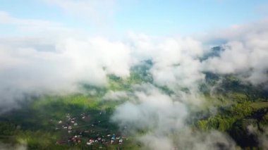 Dağlarda bulutlarda uçmak, dağlarda sabah bulutları, dağlarda sabah sisi, gün doğumunda gökyüzü ve bulutların üstünde hava manzarası, Karpatya 'da dağlarda görkemli bulutlar.