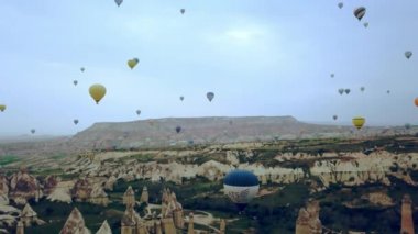 Kapadokya 'da güneş doğarken Balon' un havadan görünüşü, Cappadocia kayaları üzerinde bir sürü balon.
