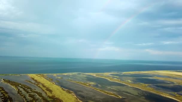 海の上の二重虹の空中ビュー 海と島の上の虹の空中ビュー 虹とDzharylgach島の空中ビュー 島の湖の空中ビューと二重虹 — ストック動画